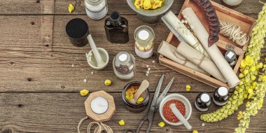 Verbascum çiçekleri, bitkisel kavanozlar, antika aletler ve ahşap masada havan topuyla kırsal eczacılık sahnesi. Alternatif tıp, sağlıklı yaşam tarzı konsepti, üst bakış.