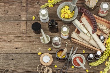 Verbascum çiçekleri, bitkisel kavanozlar, antika aletler ve ahşap masada havan topuyla kırsal eczacılık sahnesi. Alternatif tıp, sağlıklı yaşam tarzı konsepti, üst bakış.