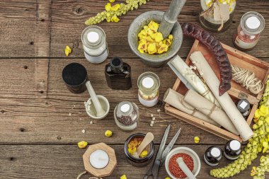 Verbascum çiçekleri, bitkisel kavanozlar, antika aletler ve ahşap masada havan topuyla kırsal eczacılık sahnesi. Alternatif tıp, sağlıklı yaşam tarzı konsepti, üst bakış.