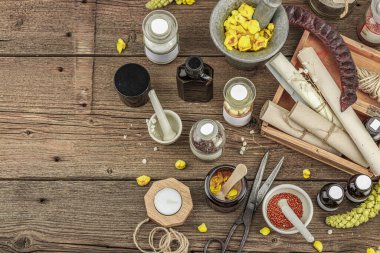 Verbascum çiçekleri, bitkisel kavanozlar, antika aletler ve ahşap masada havan topuyla kırsal eczacılık sahnesi. Alternatif tıp, sağlıklı yaşam tarzı konsepti, üst bakış.