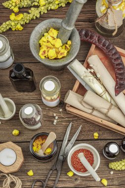 Verbascum çiçekleri, bitkisel kavanozlar, antika aletler ve ahşap masada havan topuyla kırsal eczacılık sahnesi. Alternatif tıp, sağlıklı yaşam tarzı konsepti, üst bakış.