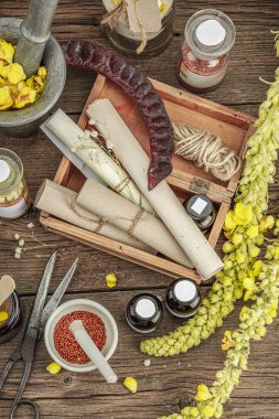 Verbascum çiçekleri, bitkisel kavanozlar, antika aletler ve ahşap masada havan topuyla kırsal eczacılık sahnesi. Alternatif tıp, sağlıklı yaşam tarzı konsepti, üst bakış.