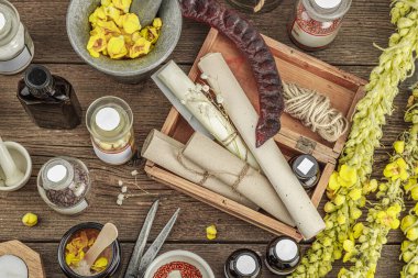 Verbascum çiçekleri, bitkisel kavanozlar, antika aletler ve ahşap masada havan topuyla kırsal eczacılık sahnesi. Alternatif tıp, sağlıklı yaşam tarzı konsepti, üst bakış.