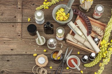 Verbascum çiçekleri, bitkisel kavanozlar, antika aletler ve ahşap masada havan topuyla kırsal eczacılık sahnesi. Alternatif tıp, sağlıklı yaşam tarzı konsepti, üst bakış.