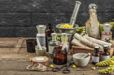 Verbascum çiçekleri, bitkisel kavanozlar, antika aletler ve ahşap masada havan topuyla kırsal eczacılık sahnesi. Alternatif tıp, sağlıklı yaşam tarzı konsepti, kopyalama alanı