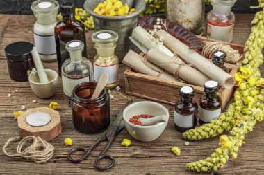 Verbascum çiçekleri, bitkisel kavanozlar, antika aletler ve ahşap masada havan topuyla kırsal eczacılık sahnesi. Alternatif tıp, sağlıklı yaşam tarzı konsepti, kopyalama alanı