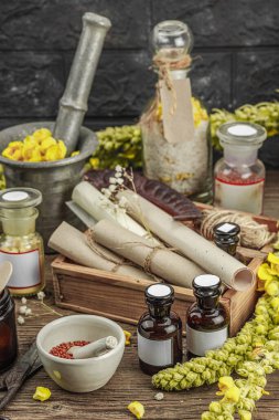 Verbascum çiçekleri, bitkisel kavanozlar, antika aletler ve ahşap masada havan topuyla kırsal eczacılık sahnesi. Alternatif tıp, sağlıklı yaşam tarzı konsepti, kapatın.