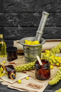 Verbascum çiçekleriyle doğal cilt bakımı, yağlar, kremler ve güzellik tedavileri için bitkisel malzeme. Siyah tahta arkaplan, boşluğu kopyala