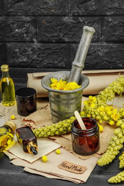 Verbascum çiçekleriyle doğal cilt bakımı, yağlar, kremler ve güzellik tedavileri için bitkisel malzeme. Siyah tahta arkaplan, boşluğu kopyala