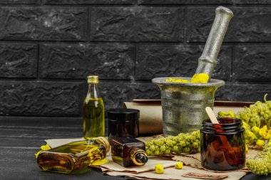 Verbascum çiçekleriyle doğal cilt bakımı, yağlar, kremler ve güzellik tedavileri için bitkisel malzeme. Siyah tahta arkaplan, boşluğu kopyala