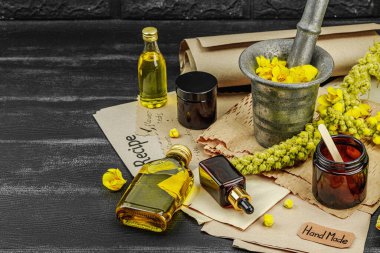 Verbascum çiçekleriyle doğal cilt bakımı, yağlar, kremler ve güzellik tedavileri için bitkisel malzeme. Siyah tahta arkaplan, boşluğu kopyala