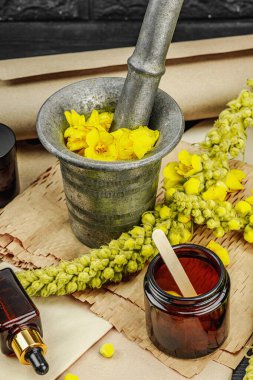 Verbascum çiçekleriyle doğal cilt bakımı, yağlar, kremler ve güzellik tedavileri için bitkisel malzeme. Siyah ahşap arkaplan, kapat