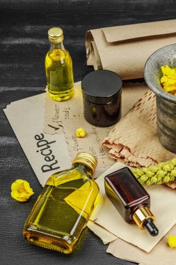 Verbascum çiçekleriyle doğal cilt bakımı, yağlar, kremler ve güzellik tedavileri için bitkisel malzeme. Siyah ahşap arkaplan, kapat