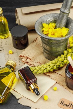 Verbascum çiçekleriyle doğal cilt bakımı, yağlar, kremler ve güzellik tedavileri için bitkisel malzeme. Siyah ahşap arkaplan, kapat