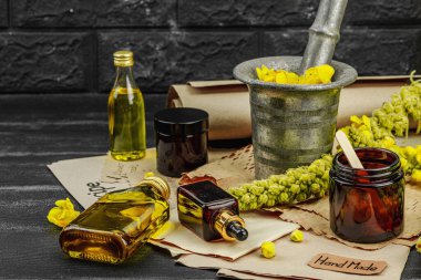 Verbascum çiçekleriyle doğal cilt bakımı, yağlar, kremler ve güzellik tedavileri için bitkisel malzeme. Siyah tahta arkaplan, boşluğu kopyala