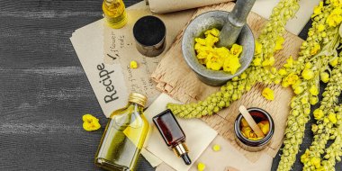 Verbascum çiçekleriyle doğal cilt bakımı, yağlar, kremler ve güzellik tedavileri için bitkisel malzeme. Siyah ahşap arkaplan, pankart biçimi