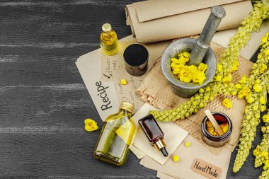 Verbascum çiçekleriyle doğal cilt bakımı, yağlar, kremler ve güzellik tedavileri için bitkisel malzeme. Siyah ahşap arkaplan, üst manzara