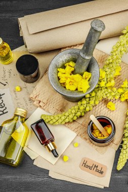 Verbascum çiçekleriyle doğal cilt bakımı, yağlar, kremler ve güzellik tedavileri için bitkisel malzeme. Siyah ahşap arkaplan, üst manzara