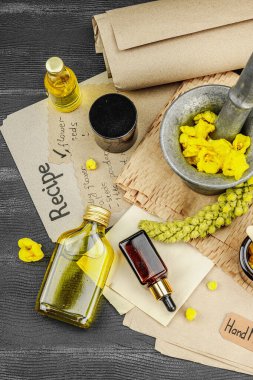 Verbascum çiçekleriyle doğal cilt bakımı, yağlar, kremler ve güzellik tedavileri için bitkisel malzeme. Siyah ahşap arkaplan, üst manzara