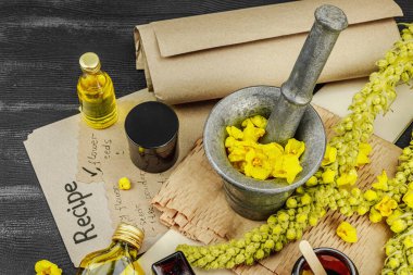 Verbascum çiçekleriyle doğal cilt bakımı, yağlar, kremler ve güzellik tedavileri için bitkisel malzeme. Siyah ahşap arkaplan, üst manzara