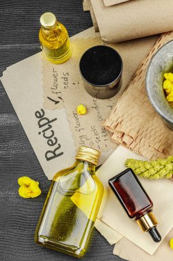 Verbascum çiçekleriyle doğal cilt bakımı, yağlar, kremler ve güzellik tedavileri için bitkisel malzeme. Siyah ahşap arkaplan, üst manzara