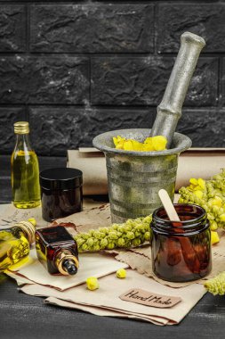 Verbascum çiçekleriyle doğal cilt bakımı, yağlar, kremler ve güzellik tedavileri için bitkisel malzeme. Siyah tahta arkaplan, boşluğu kopyala