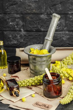 Verbascum çiçekleriyle doğal cilt bakımı, yağlar, kremler ve güzellik tedavileri için bitkisel malzeme. Siyah tahta arkaplan, boşluğu kopyala