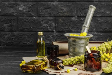 Verbascum çiçekleriyle doğal cilt bakımı, yağlar, kremler ve güzellik tedavileri için bitkisel malzeme. Siyah tahta arkaplan, boşluğu kopyala