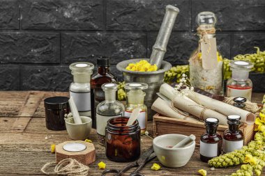 Verbascum çiçekleri, bitkisel kavanozlar, antika aletler ve ahşap masada havan topuyla kırsal eczacılık sahnesi. Alternatif tıp, sağlıklı yaşam tarzı konsepti, kopyalama alanı