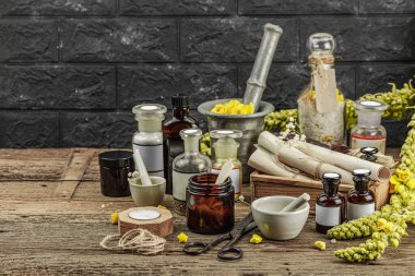 Verbascum çiçekleri, bitkisel kavanozlar, antika aletler ve ahşap masada havan topuyla kırsal eczacılık sahnesi. Alternatif tıp, sağlıklı yaşam tarzı konsepti, kopyalama alanı