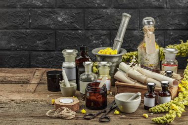 Verbascum çiçekleri, bitkisel kavanozlar, antika aletler ve ahşap masada havan topuyla kırsal eczacılık sahnesi. Alternatif tıp, sağlıklı yaşam tarzı konsepti, kopyalama alanı