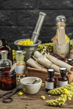 Verbascum çiçekleri, bitkisel kavanozlar, antika aletler ve ahşap masada havan topuyla kırsal eczacılık sahnesi. Alternatif tıp, sağlıklı yaşam tarzı konsepti, kopyalama alanı