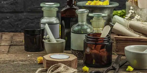 Verbascum çiçekleri, bitkisel kavanozlar, antika aletler ve ahşap masada havan topuyla kırsal eczacılık sahnesi. Alternatif tıp, sağlıklı yaşam tarzı konsepti, afiş biçimi