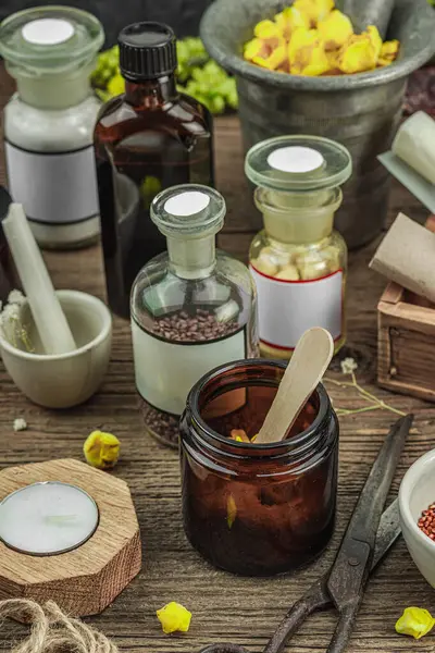 Verbascum çiçekleri, bitkisel kavanozlar, antika aletler ve ahşap masada havan topuyla kırsal eczacılık sahnesi. Alternatif tıp, sağlıklı yaşam tarzı konsepti, kapatın.