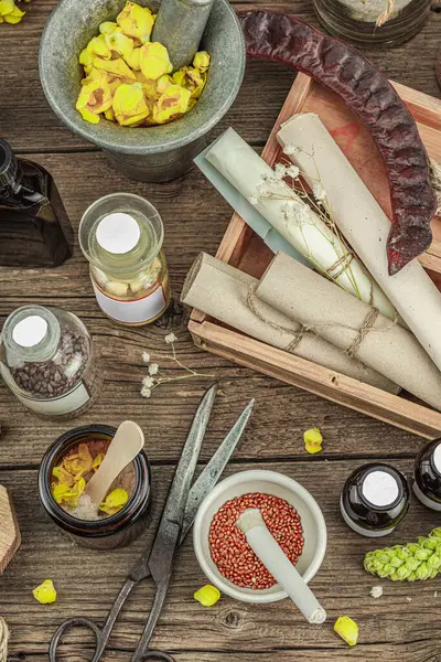 Verbascum çiçekleri, bitkisel kavanozlar, antika aletler ve ahşap masada havan topuyla kırsal eczacılık sahnesi. Alternatif tıp, sağlıklı yaşam tarzı konsepti, üst bakış.