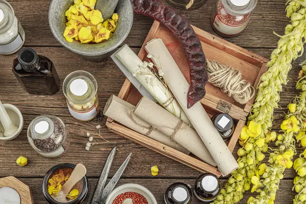 Verbascum çiçekleri, bitkisel kavanozlar, antika aletler ve ahşap masada havan topuyla kırsal eczacılık sahnesi. Alternatif tıp, sağlıklı yaşam tarzı konsepti, üst bakış.