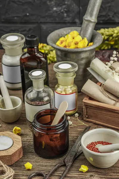 Verbascum çiçekleri, bitkisel kavanozlar, antika aletler ve ahşap masada havan topuyla kırsal eczacılık sahnesi. Alternatif tıp, sağlıklı yaşam tarzı konsepti, kapatın.