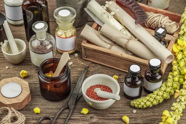 Verbascum çiçekleri, bitkisel kavanozlar, antika aletler ve ahşap masada havan topuyla kırsal eczacılık sahnesi. Alternatif tıp, sağlıklı yaşam tarzı konsepti, kapatın.