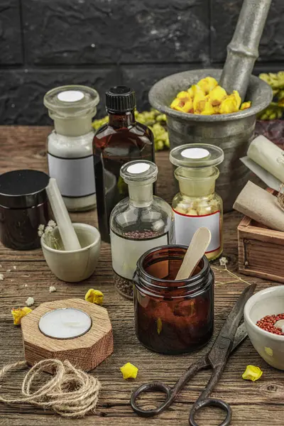 Verbascum çiçekleri, bitkisel kavanozlar, antika aletler ve ahşap masada havan topuyla kırsal eczacılık sahnesi. Alternatif tıp, sağlıklı yaşam tarzı konsepti, kapatın.