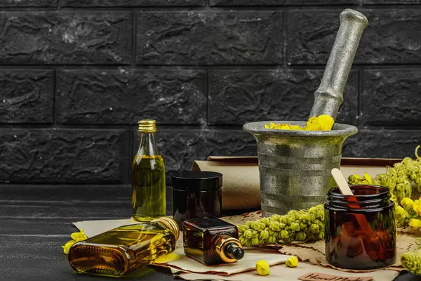 Verbascum çiçekleriyle doğal cilt bakımı, yağlar, kremler ve güzellik tedavileri için bitkisel malzeme. Siyah tahta arkaplan, boşluğu kopyala