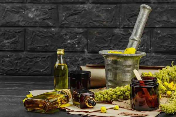 Verbascum çiçekleriyle doğal cilt bakımı, yağlar, kremler ve güzellik tedavileri için bitkisel malzeme. Siyah tahta arkaplan, boşluğu kopyala