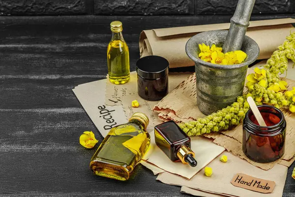 Verbascum çiçekleriyle doğal cilt bakımı, yağlar, kremler ve güzellik tedavileri için bitkisel malzeme. Siyah tahta arkaplan, boşluğu kopyala