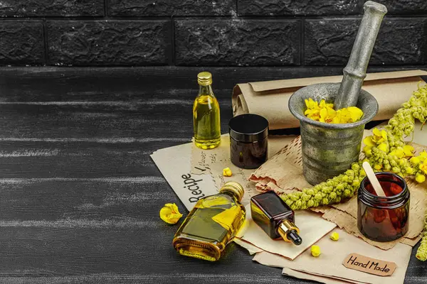 Verbascum çiçekleriyle doğal cilt bakımı, yağlar, kremler ve güzellik tedavileri için bitkisel malzeme. Siyah tahta arkaplan, boşluğu kopyala