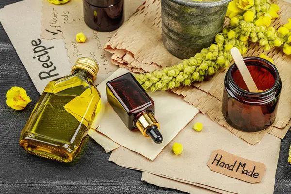 Verbascum çiçekleriyle doğal cilt bakımı, yağlar, kremler ve güzellik tedavileri için bitkisel malzeme. Siyah ahşap arkaplan, kapat