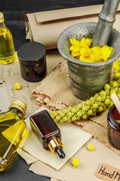 Verbascum çiçekleriyle doğal cilt bakımı, yağlar, kremler ve güzellik tedavileri için bitkisel malzeme. Siyah ahşap arkaplan, kapat