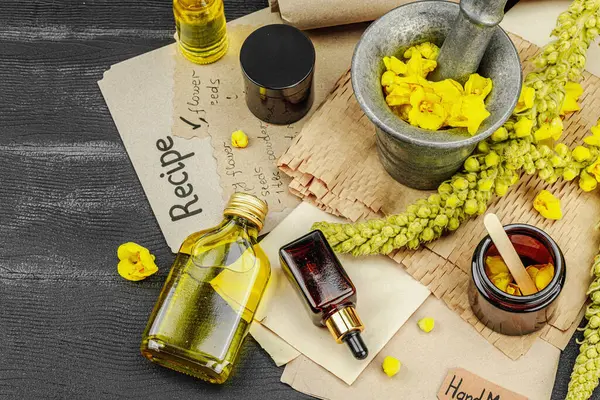 Verbascum çiçekleriyle doğal cilt bakımı, yağlar, kremler ve güzellik tedavileri için bitkisel malzeme. Siyah ahşap arkaplan, üst manzara