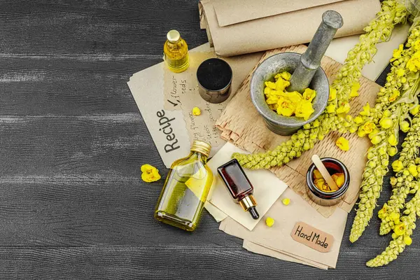 Verbascum çiçekleriyle doğal cilt bakımı, yağlar, kremler ve güzellik tedavileri için bitkisel malzeme. Siyah ahşap arkaplan, üst manzara