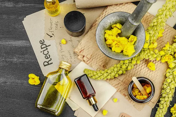 Verbascum çiçekleriyle doğal cilt bakımı, yağlar, kremler ve güzellik tedavileri için bitkisel malzeme. Siyah ahşap arkaplan, üst manzara