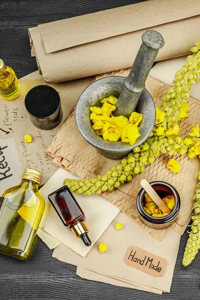 Verbascum çiçekleriyle doğal cilt bakımı, yağlar, kremler ve güzellik tedavileri için bitkisel malzeme. Siyah ahşap arkaplan, üst manzara