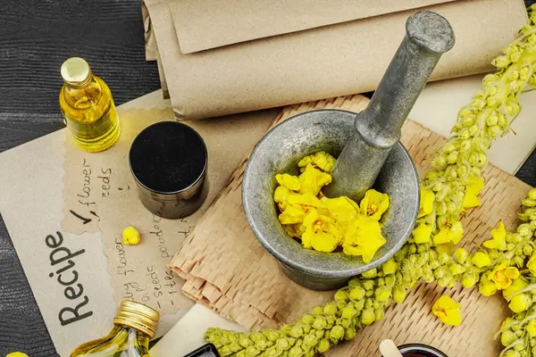 Verbascum çiçekleriyle doğal cilt bakımı, yağlar, kremler ve güzellik tedavileri için bitkisel malzeme. Siyah ahşap arkaplan, üst manzara